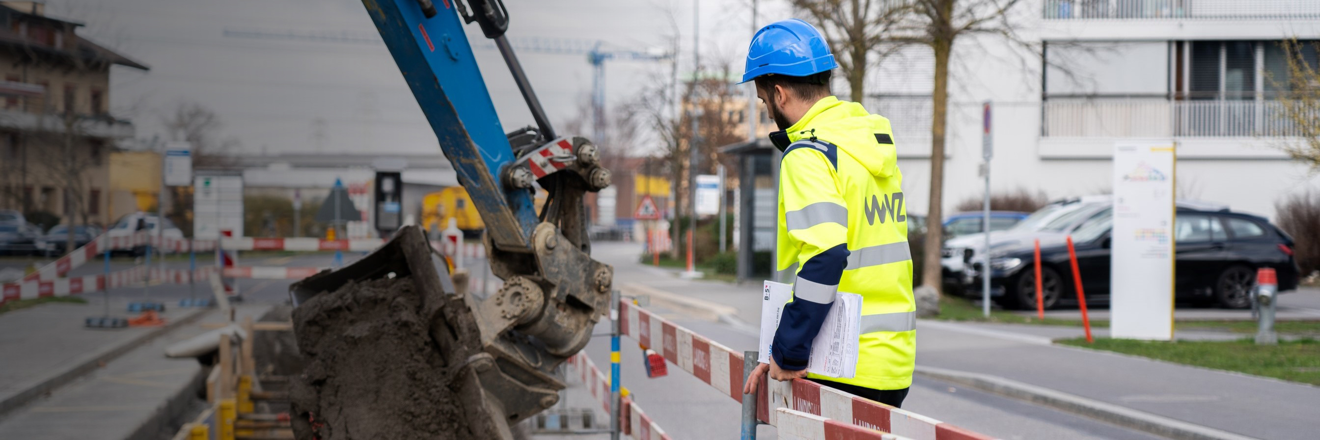 WWZ-Arbeiter steht bei Baustelle mit Bagger