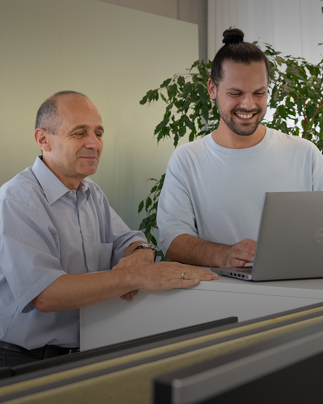 Drei Mitarbeiter besprechen und laufen vor Gebäude. 