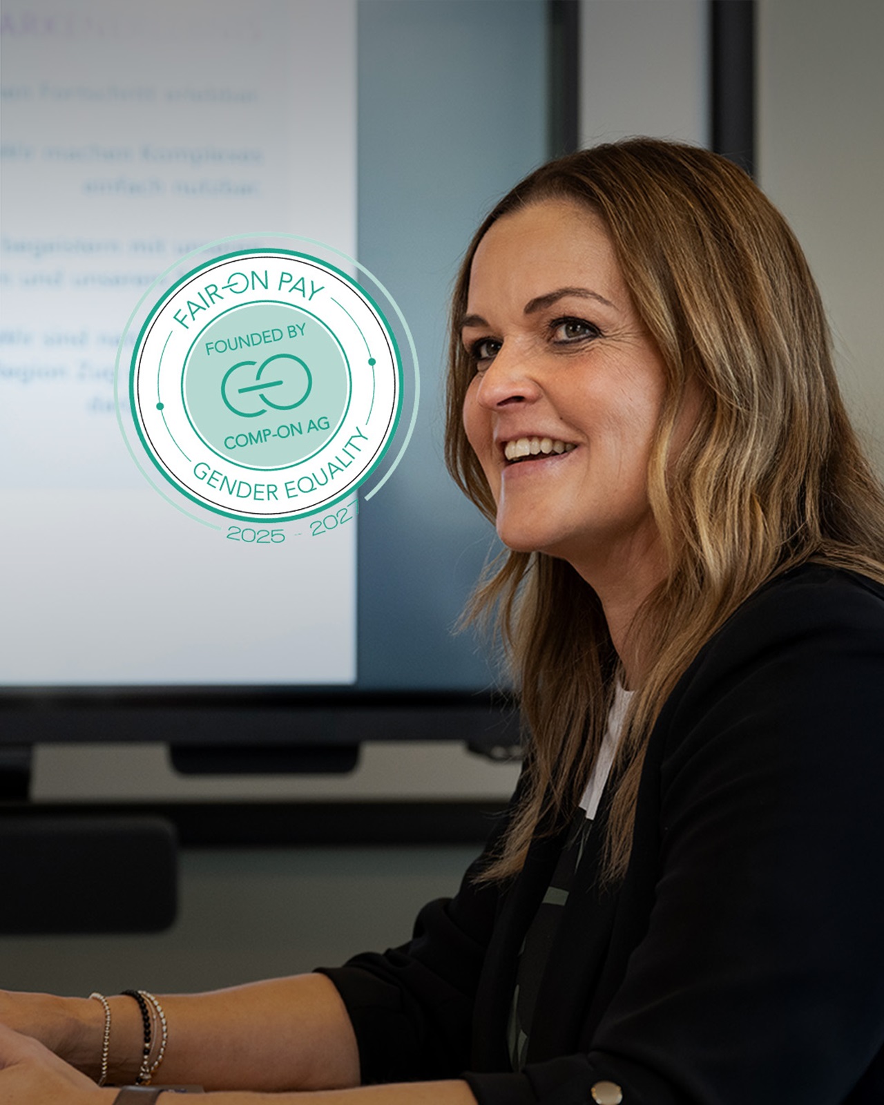 Eine lachende Mitarbeitende in Besprechung.