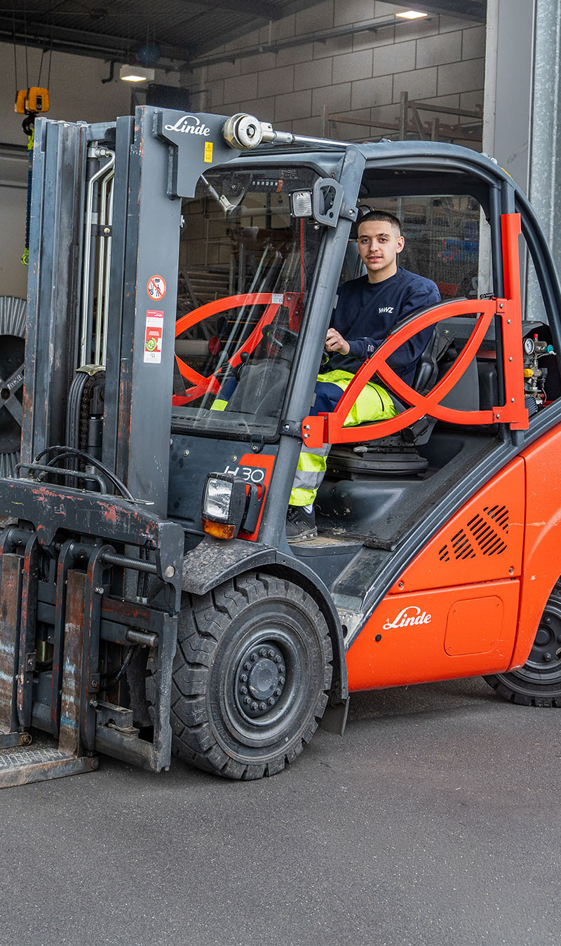 Logistiker in WWZ-Arbeitskleidung mit Gabelstapler