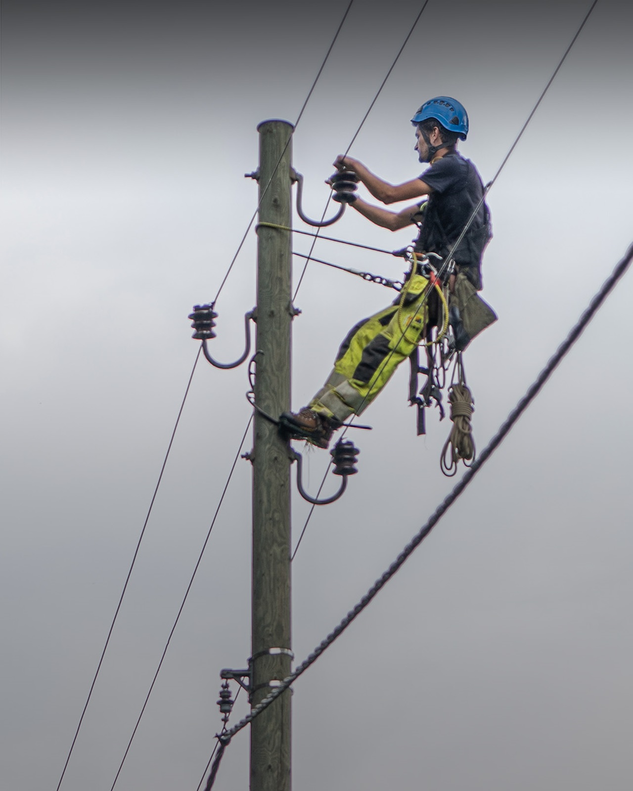 Netzelektriker hängt an Strommast.