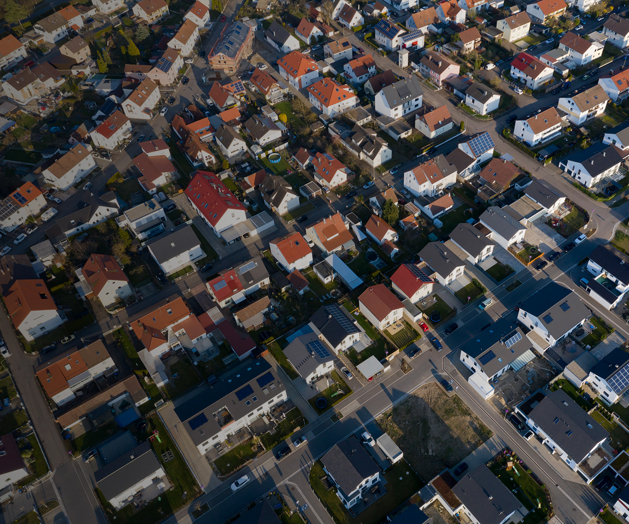 Luftaufnahme einer Gemeinde mit Solar Anlagen.