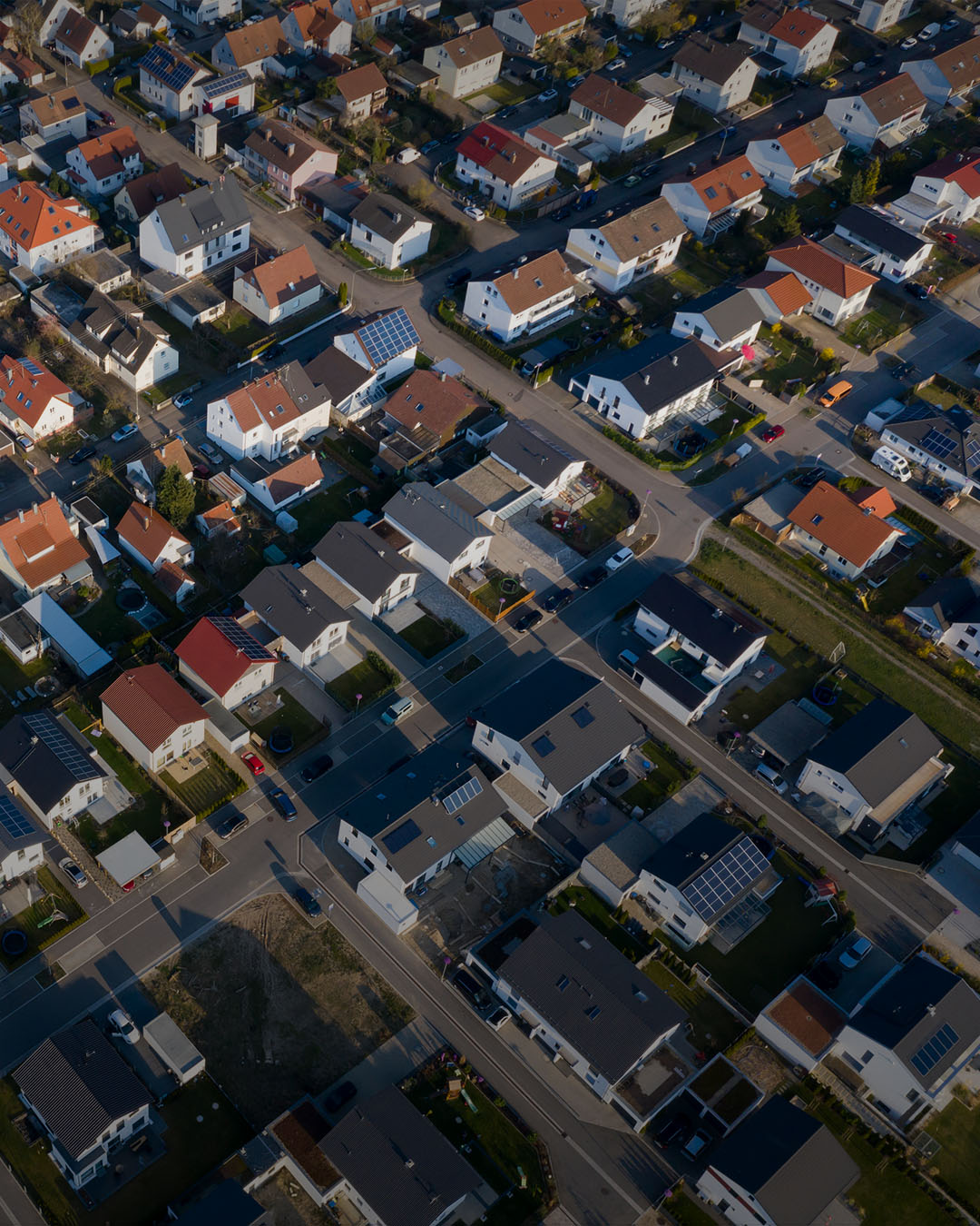Luftaufnahme einer Gemeinde mit Solar Anlagen.