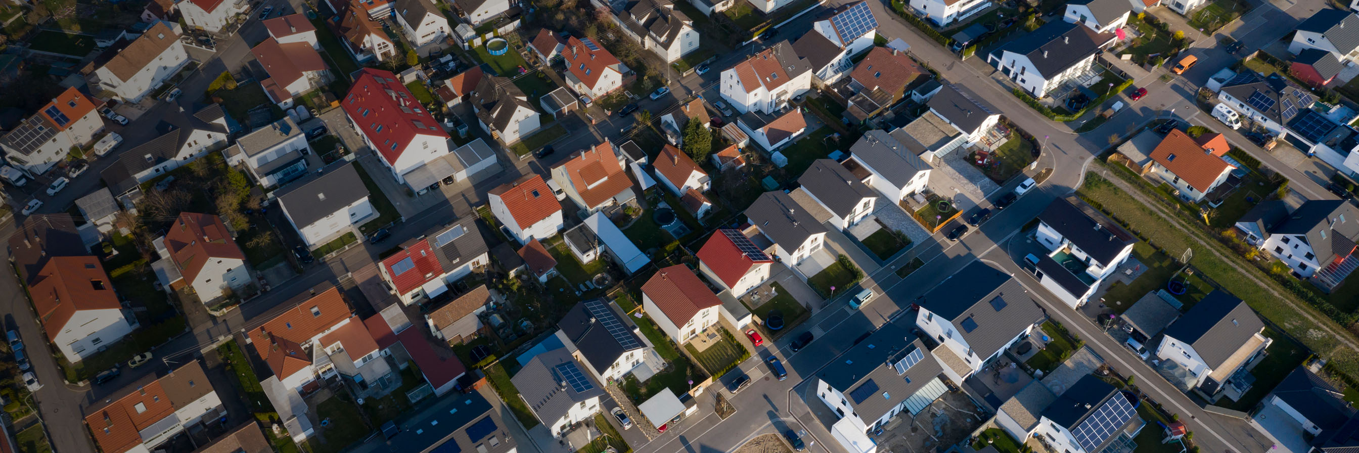 Luftaufnahme einer Gemeinde mit Solar Anlagen.