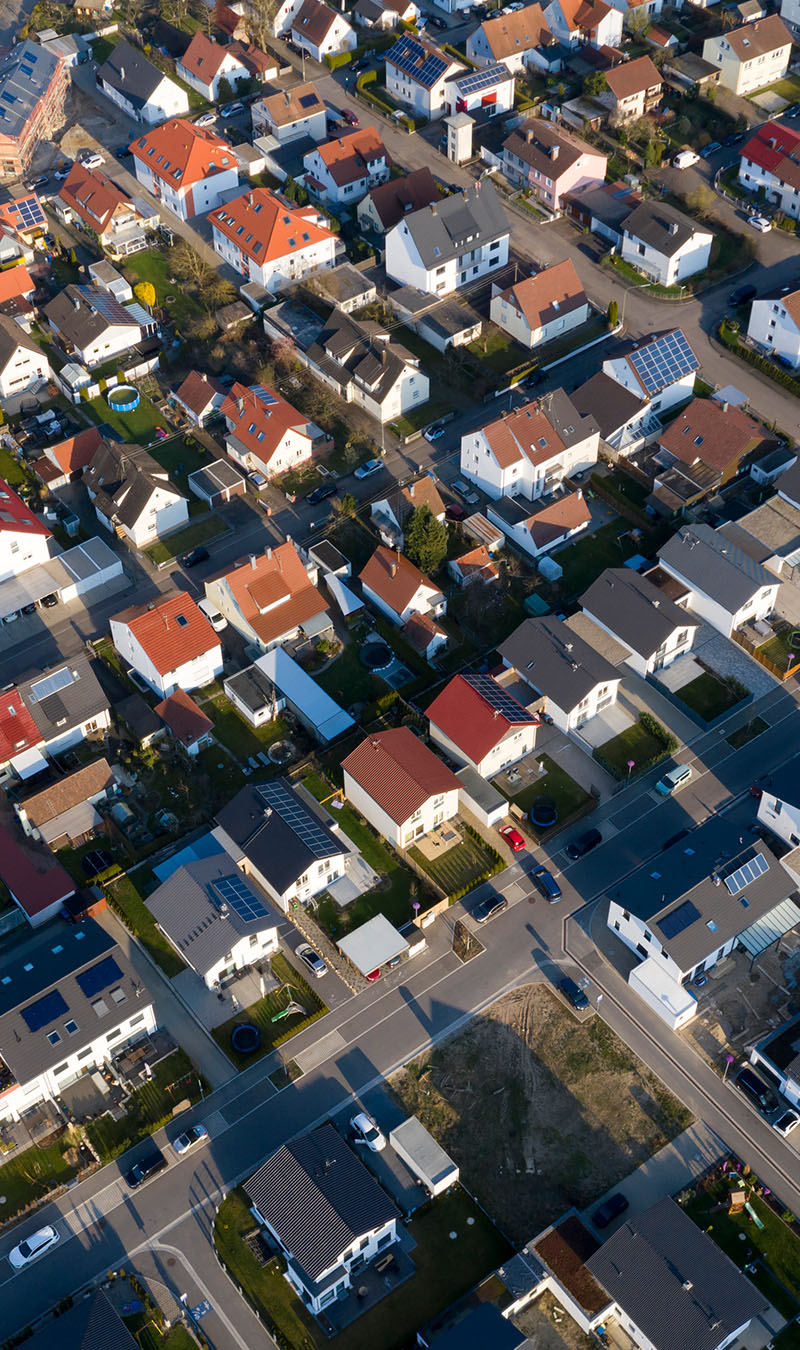 Luftaufnahme einer Gemeinde mit Solar Anlagen.