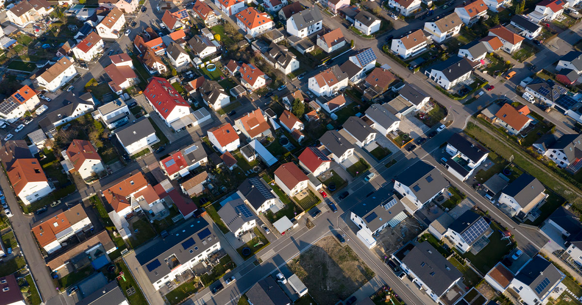 Luftaufnahme einer Gemeinde mit Solar Anlagen.