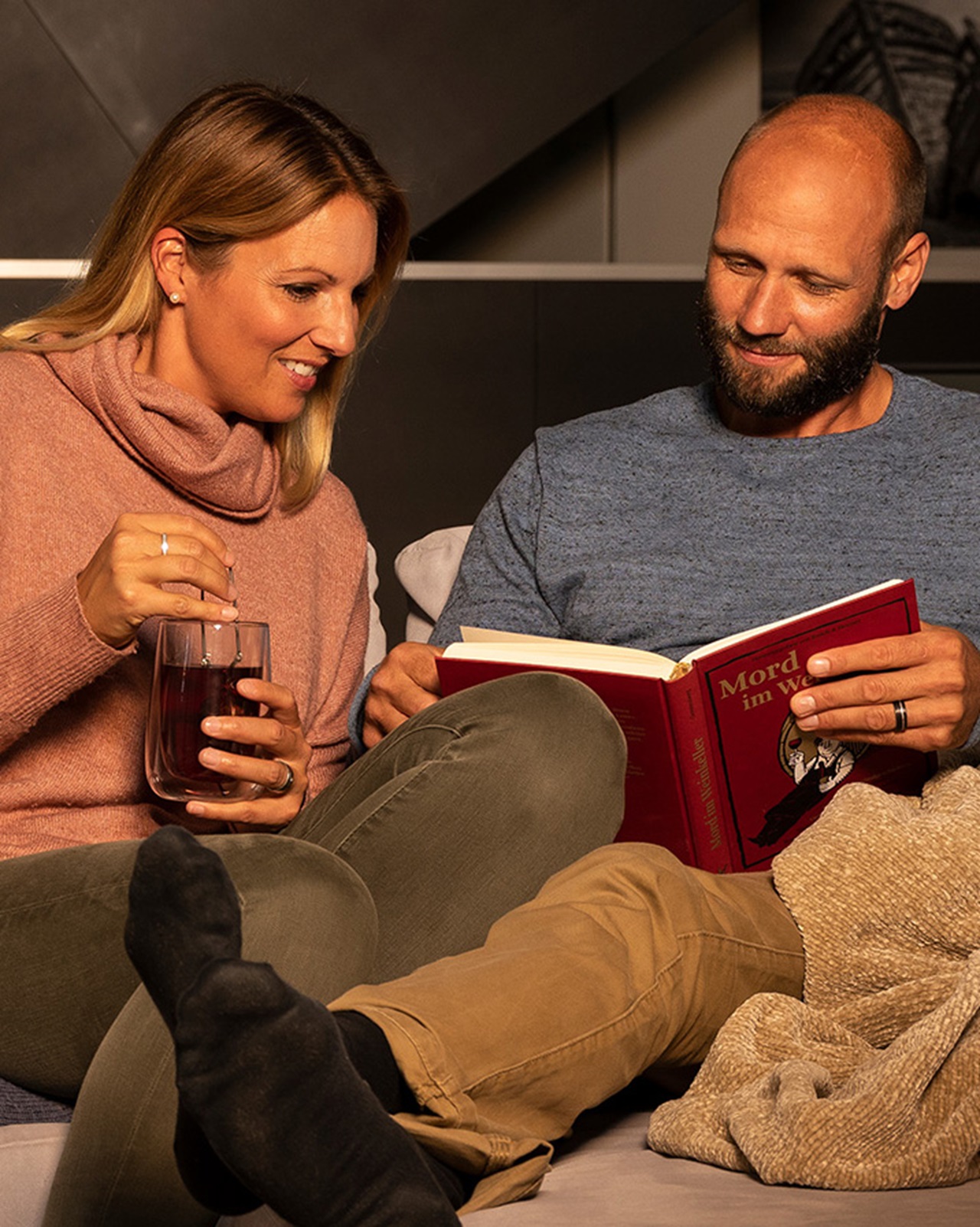 Mann und Frau in der warmen Stube beim gemeinsamen Lesen eines Buches.