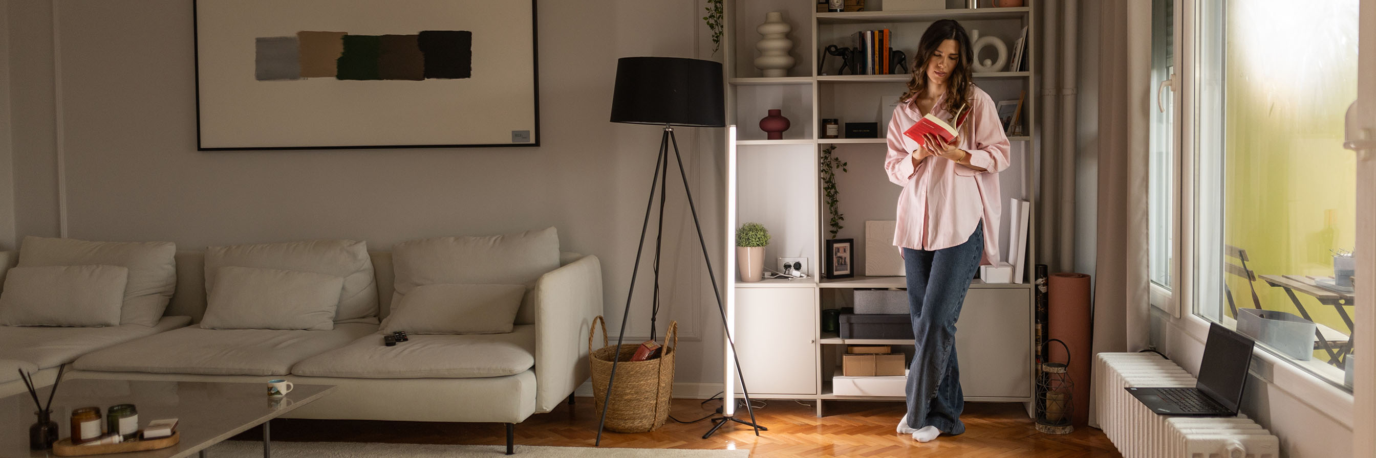 Frau vor Fenster in moderner Wohnung.