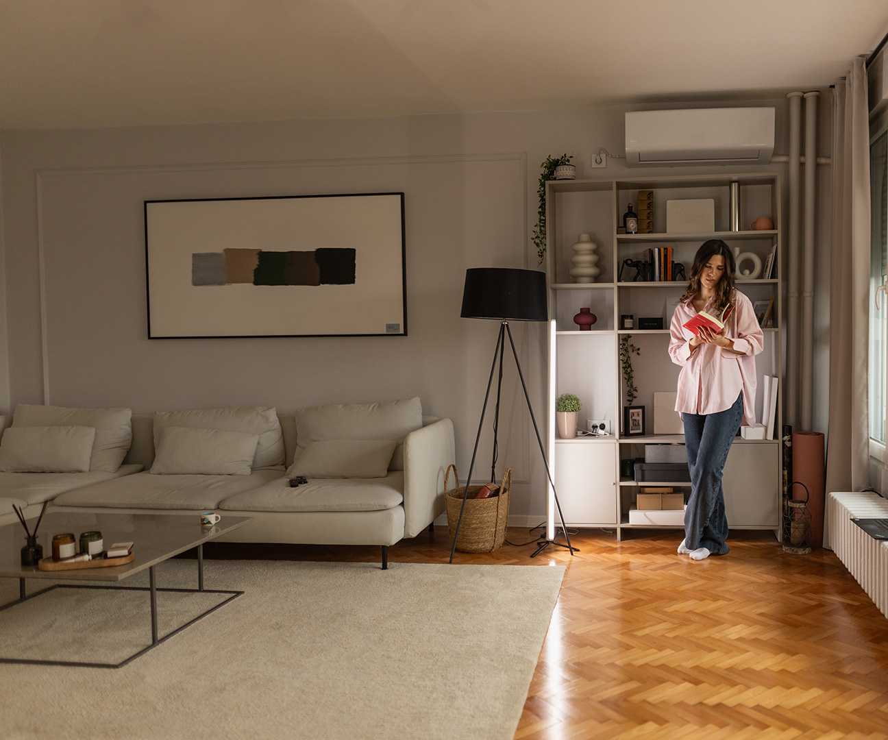 Frau vor Fenster in moderner Wohnung.