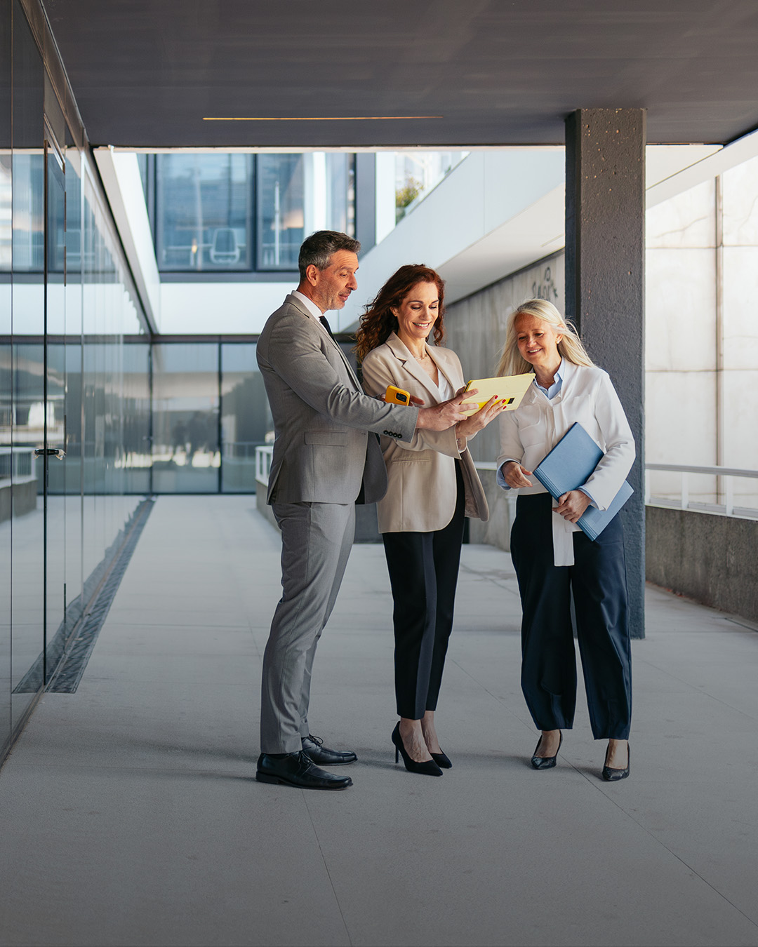 Kunden und Berater besprechen in einem Gebäudekomplex