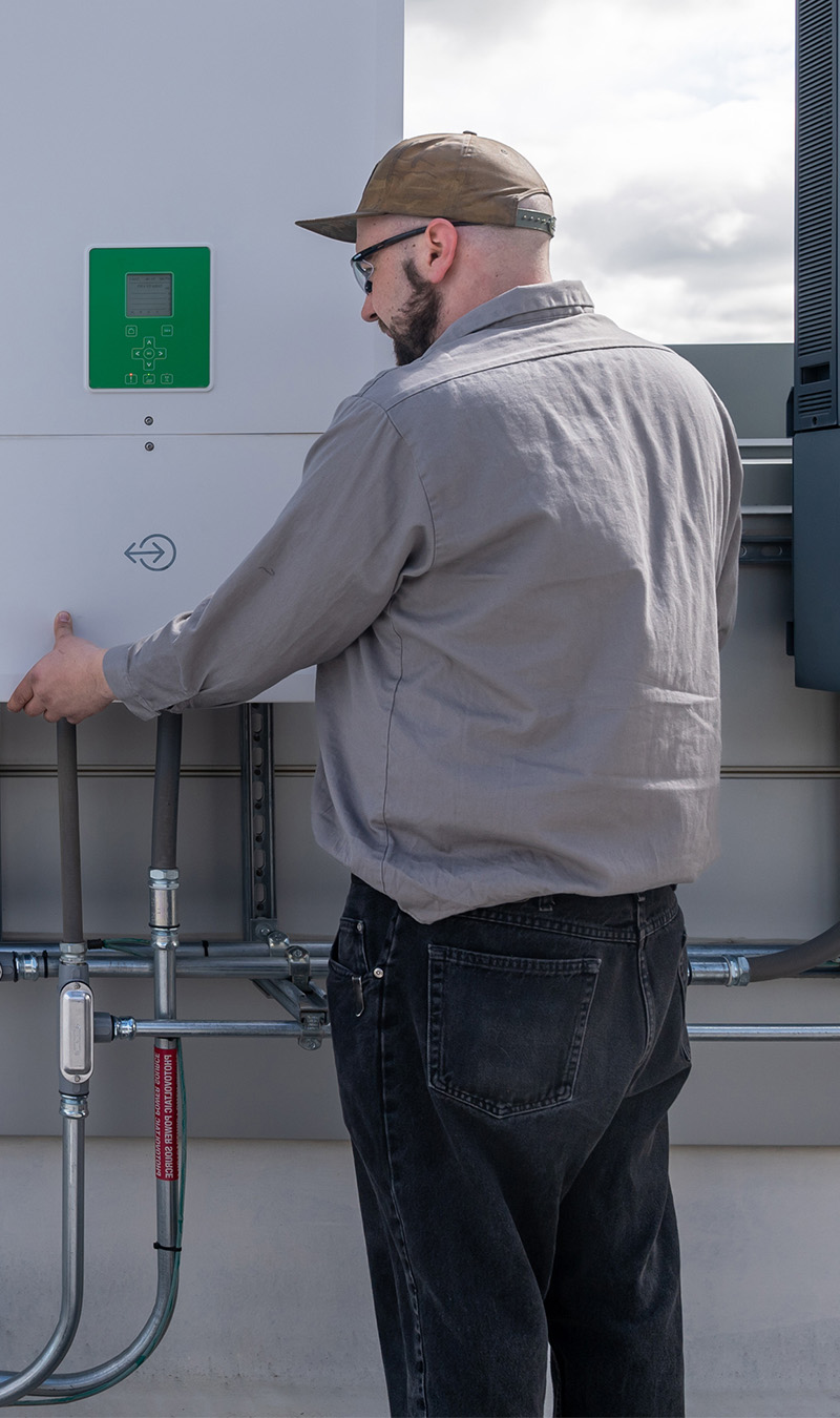 Techniker arbeitet an einem Haus mit Solaranlage.