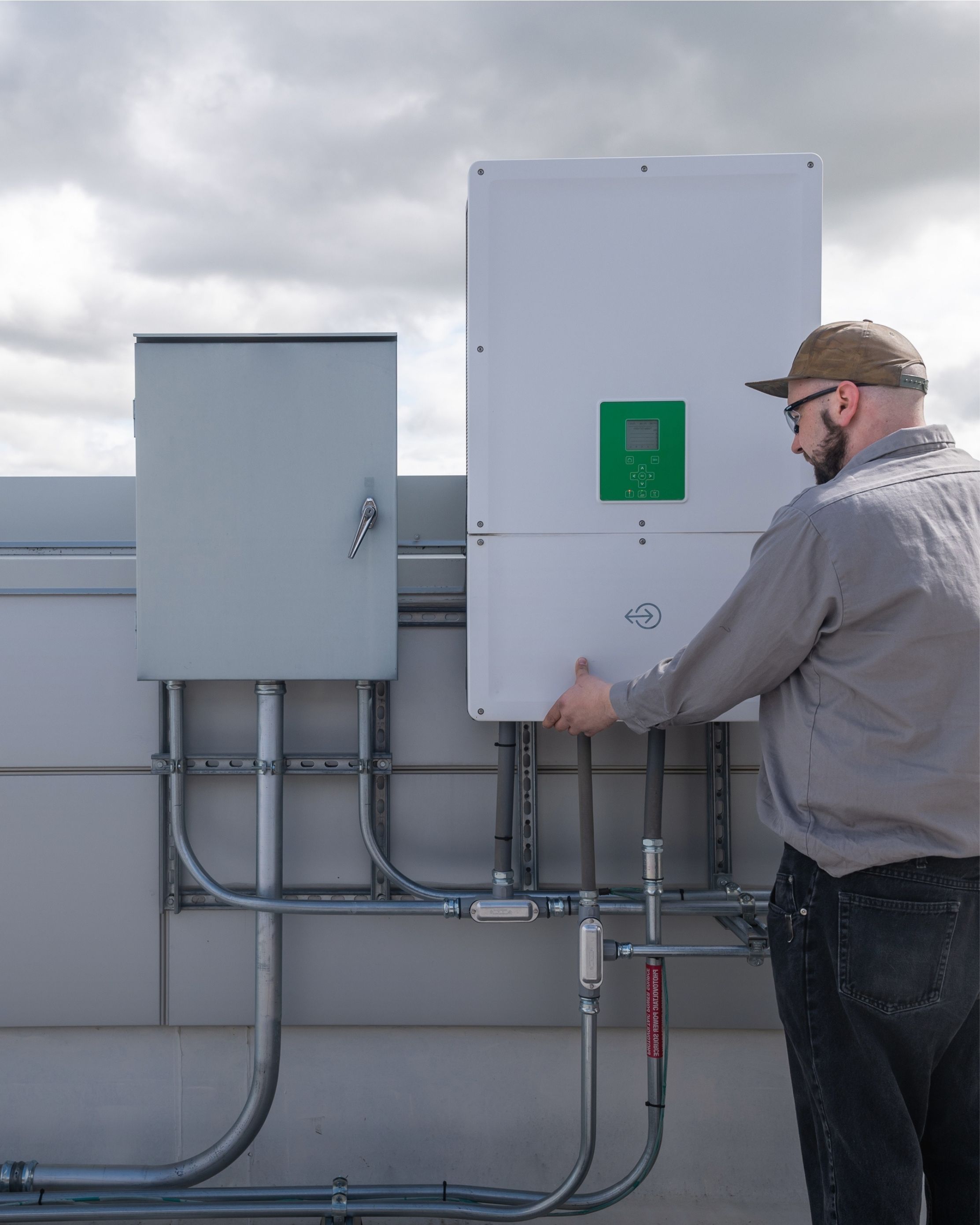 Techniker arbeitet an einem Haus mit Solaranlage.