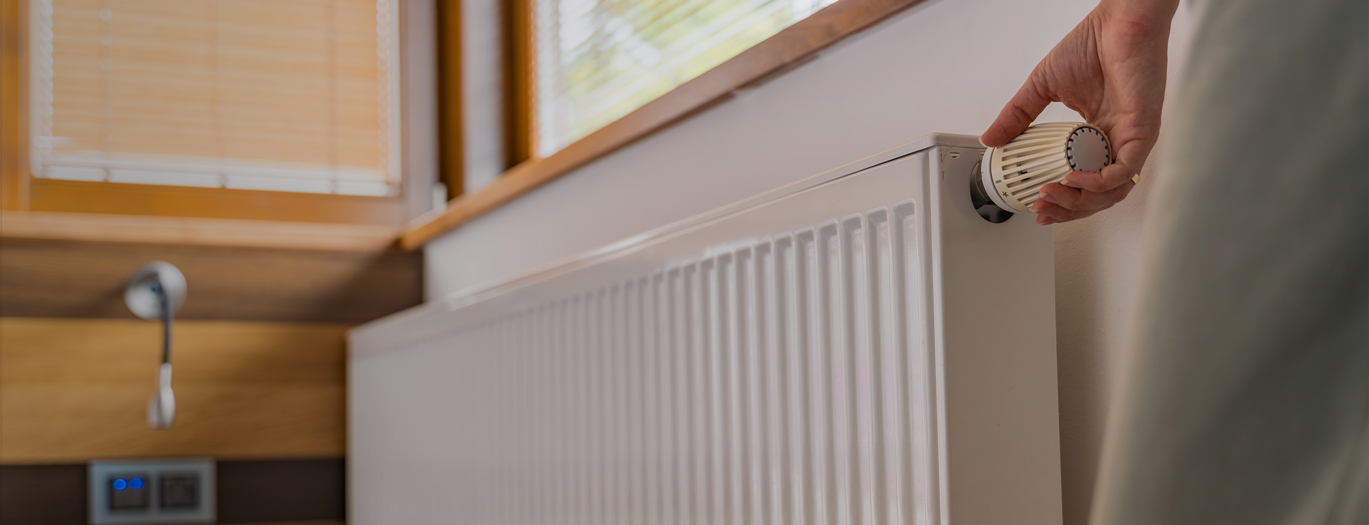 Frau dreht an Heizung